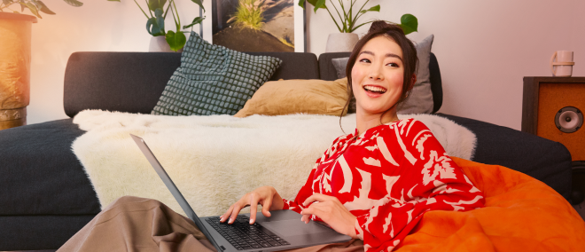 Person working on a laptop from their bedroom.
