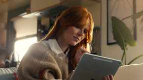 Person in their living room looking at a tablet.