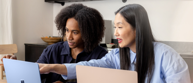 Two people looking at a laptop screen while one points.