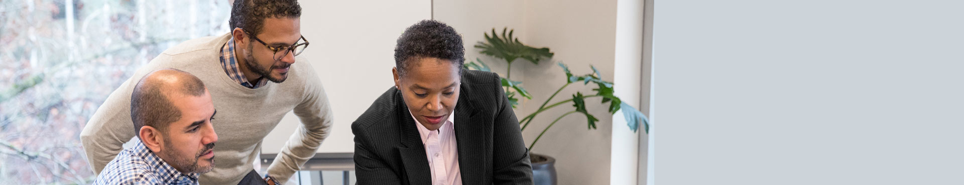 Three professionals view a presentation.
