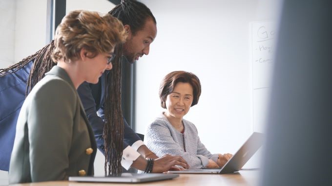 Satisfied executive customer working and collaborating with investment advisor on investment decisions using intelligent apps powered by Azure.