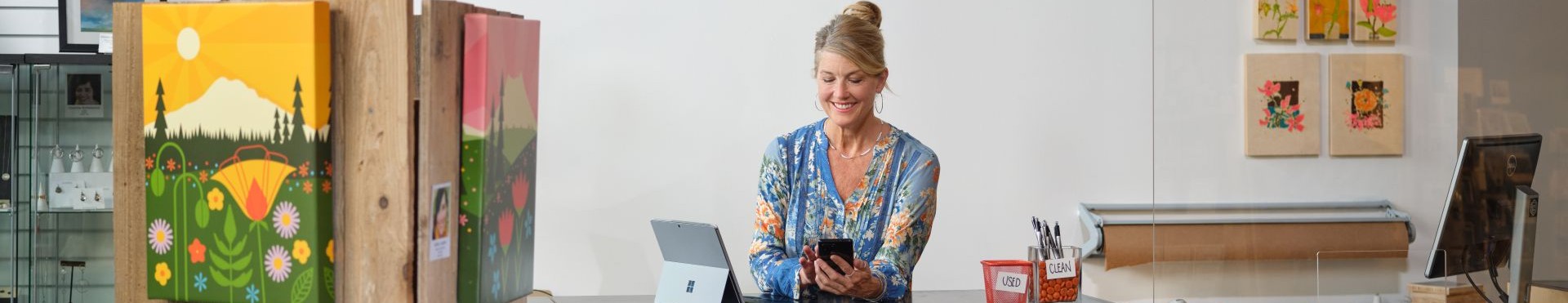 Woman in art studio with Microsoft Surface open next to her.