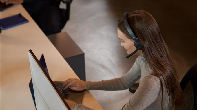 Woman wearing a headset working on laptop
