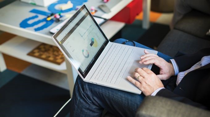 Person working on a laptop while sitting on a couch