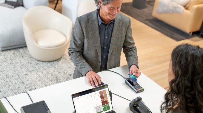 Surface Pro 9 используется в качестве POS-системы, которая подключается к устройству для оплаты и сканеру штрих-кодов. Клиент касается устройства для оплаты. Беспрепятственное оформление заказов. Store Commerce для Dynamics 365.