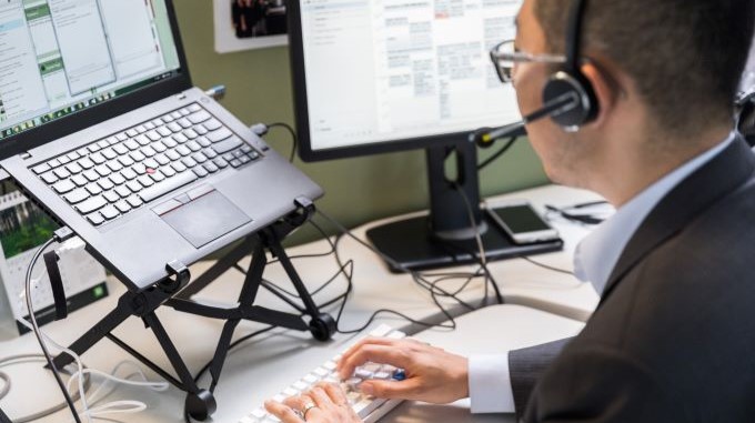 Man working on computer with a headset on