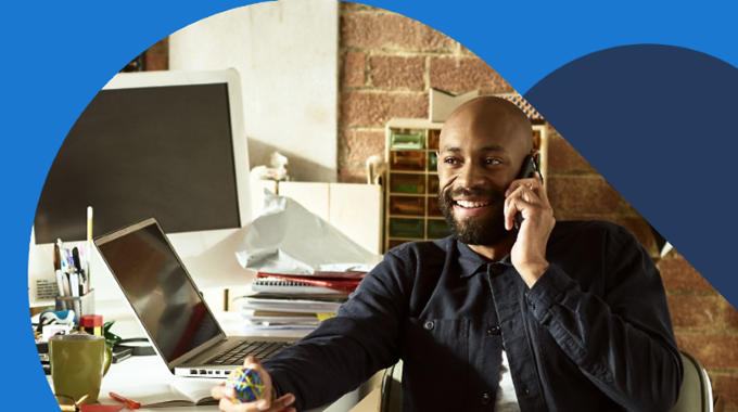 Person sitting at desk talking on their cell phone