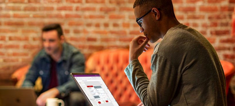 Zwei Mitarbeiter in einem Unternehmen, die an Laptops arbeiten