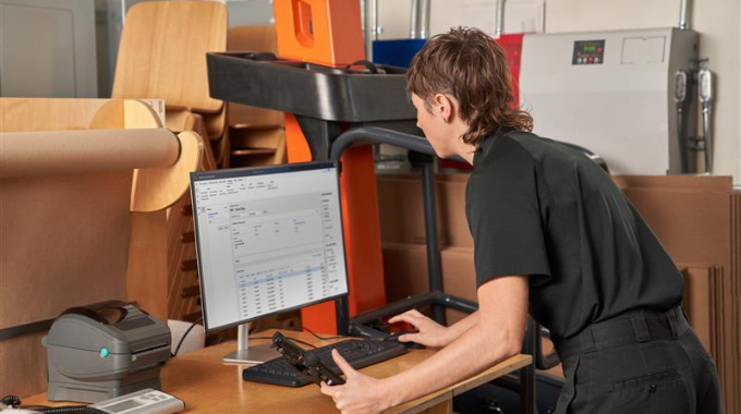 Person leaning over desk working on computer