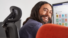 A person sitting at their desk laughing.