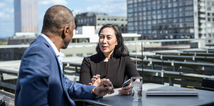 Two colleagues chat on the office balcony.