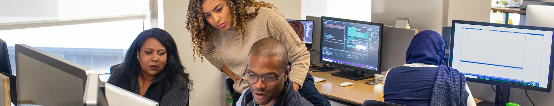 Team collaborating at computers in an office.