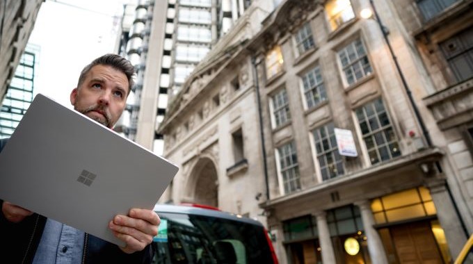 Man walking down the street with tablet in hand