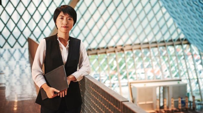 Mujer con un chaleco negro sosteniendo una tableta en la Biblioteca Pública de Seattle