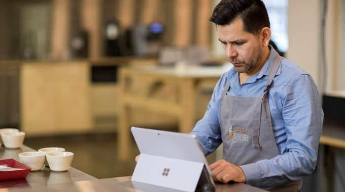 Man using Microsoft Surface tablet in Cafe